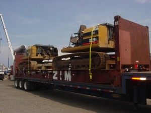 2 backhoes loaded onto a flat rack